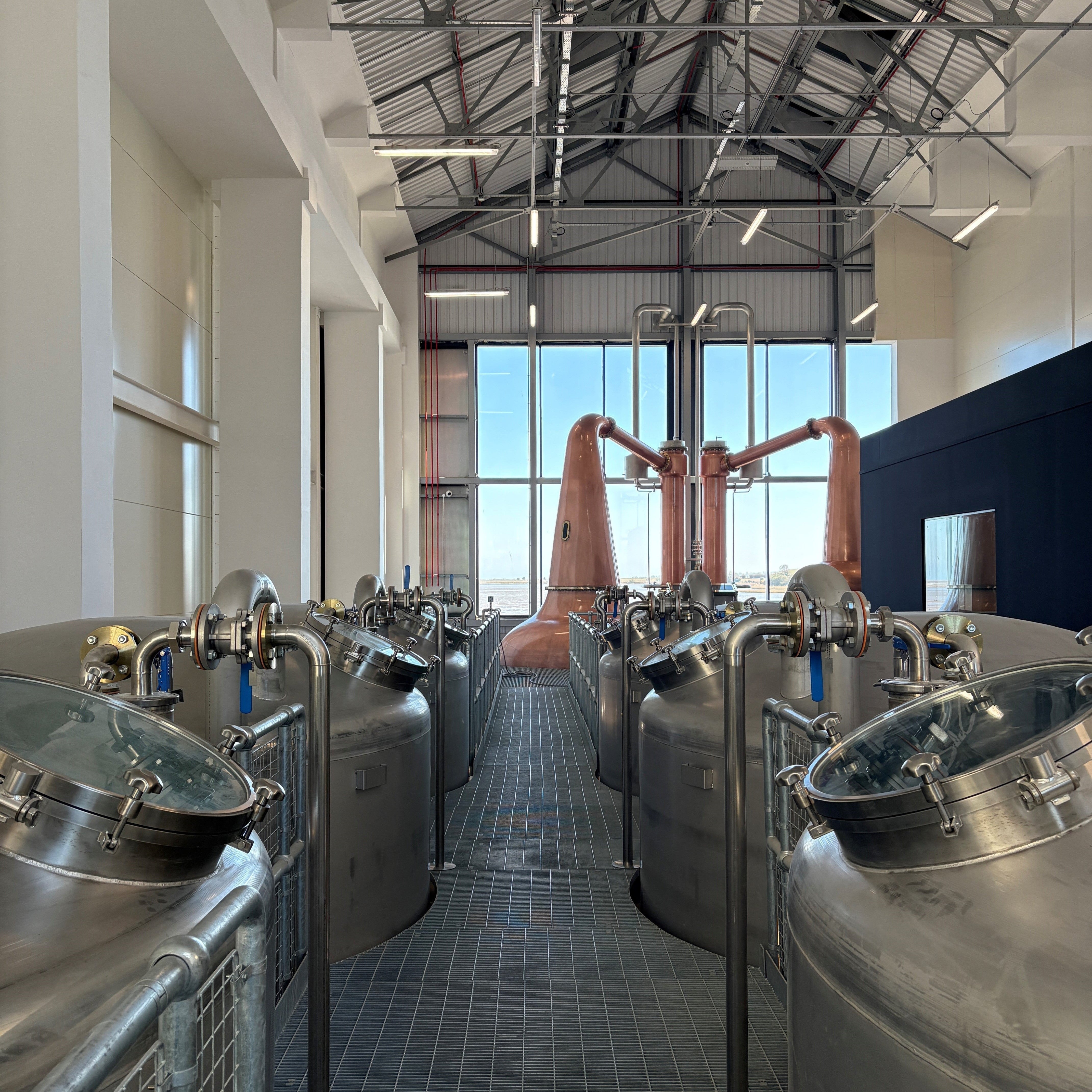 Brewery interior with large metal tanks and copper equipment.