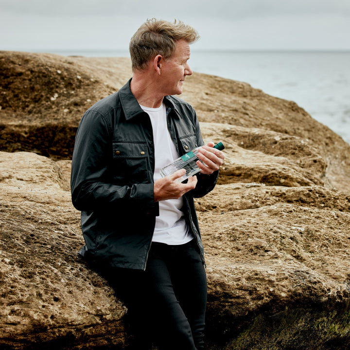 Gordon Ramsay holding a bottle of his own Ramsay Gin by Eden Mill
