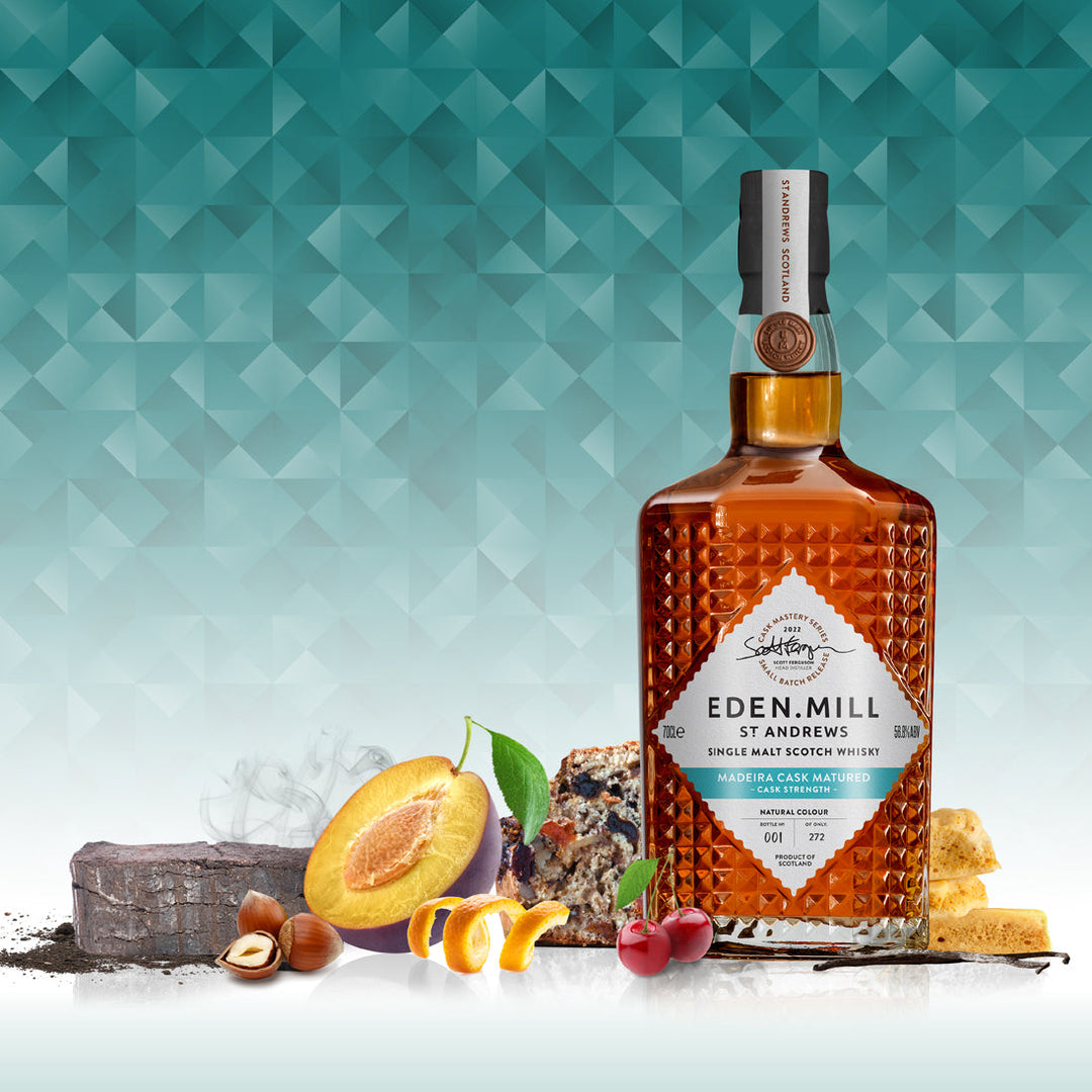 Madeira Cask Single Malt Whisky Bottle on blue abstract background and visuals of fruit and christmas cake